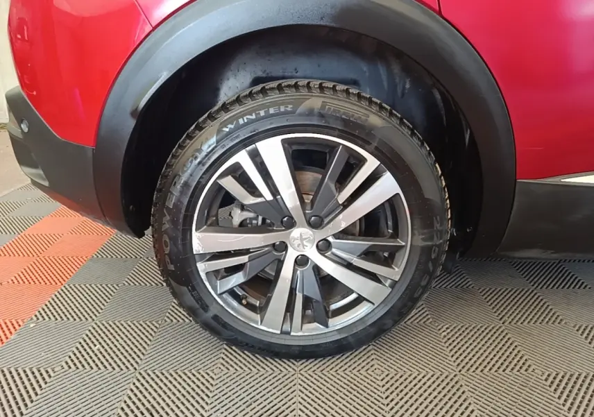 Gros plan sur la roue arrière gauche du Peugeot 3008 rouge, avec jante alliage et pneus hiver Pirelli.