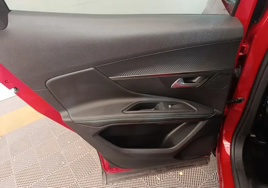Vue intérieure de la porte avant gauche rouge du Peugeot 3008 PureTech 130 S&S Allure avec garniture noire et surpiqûres bleues.