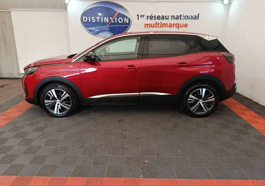 Vue latérale droite d'un Peugeot 3008 PureTech 130 rouge avec toit noir et jantes alliage bicolores en showroom.