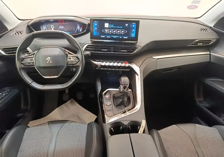 Vue intérieure avant du Peugeot 3008 PureTech 130 S&S Allure 2021, tableau de bord noir avec écran tactile central et volant cuir.