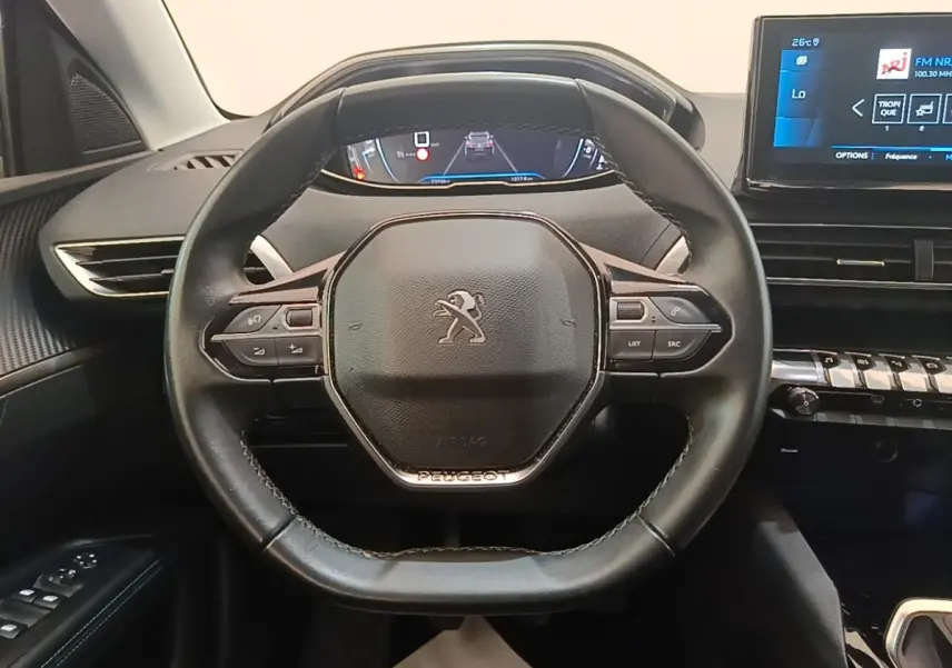 Vue intérieure centrée sur le volant cuir noir du Peugeot 3008 avec tableau de bord numérique et écran tactile.