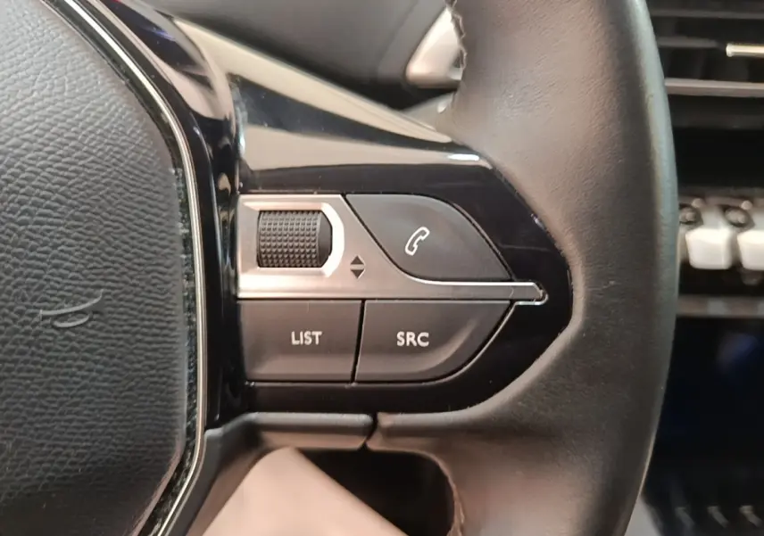 Gros plan sur les commandes gauche du volant cuir noir du Peugeot 3008 PureTech 130 S&S Allure 2021.