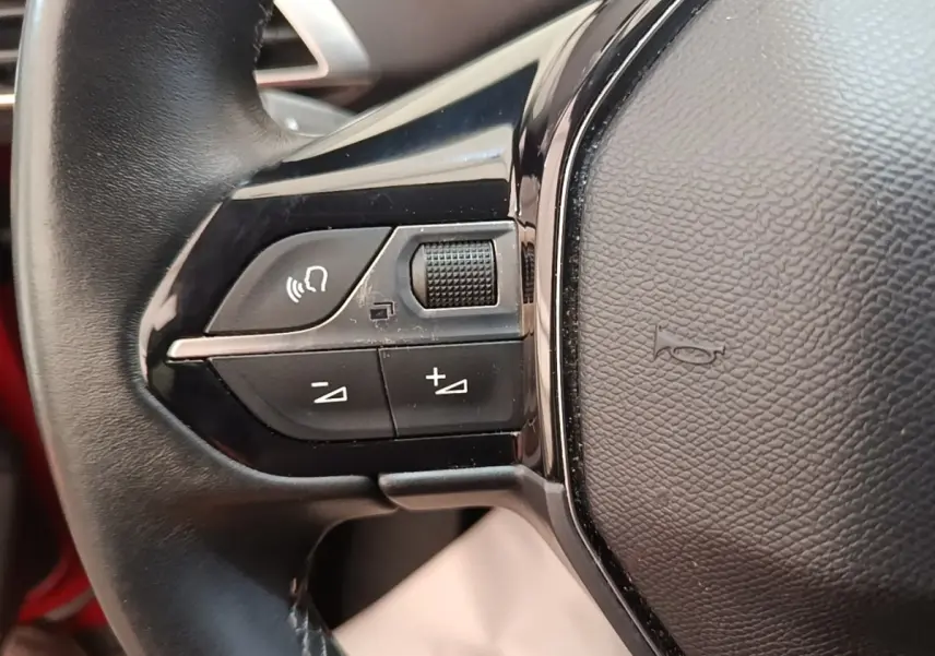 Gros plan sur le côté gauche du volant noir du Peugeot 3008 PureTech 130 S&S Allure, avec commandes intégrées.