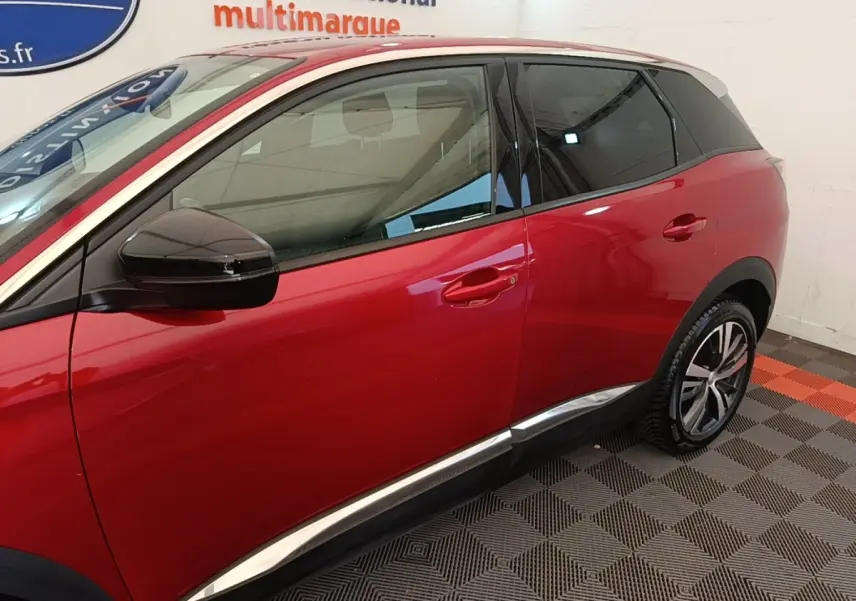 Vue latérale droite du Peugeot 3008 rouge avec toit blanc et rétroviseur noir brillant dans un showroom.