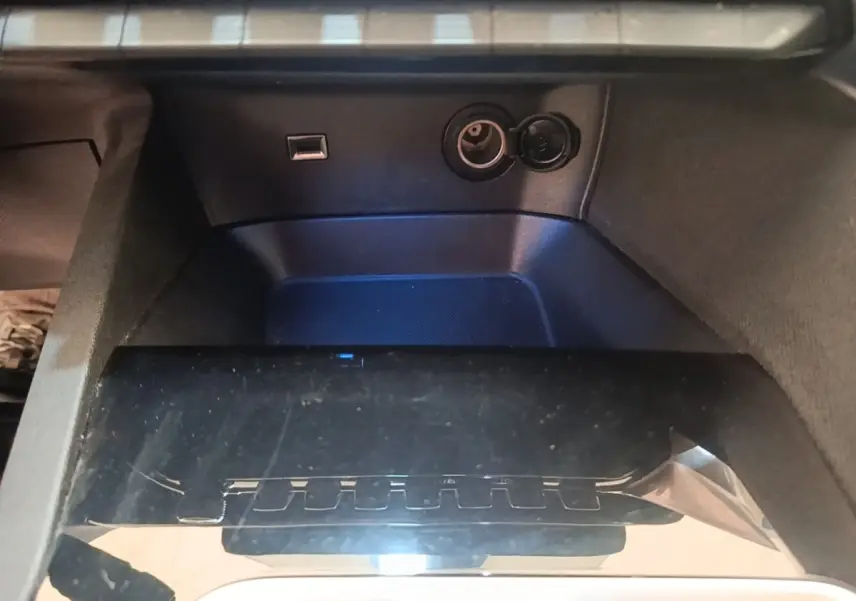 Vue rapprochée de la console centrale noire du Peugeot 3008 PureTech 130 S&S Allure avec prise USB et prise 12V.