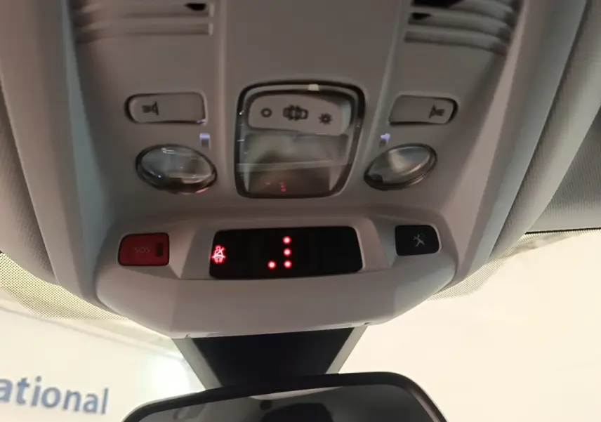 Vue intérieure du plafonnier gris clair du Peugeot 3008 PureTech 130 S&S Allure avec boutons SOS et éclairage.