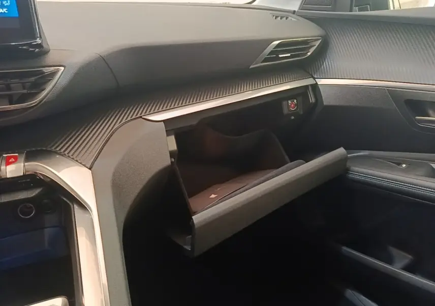 Intérieur du Peugeot 3008 PureTech 130 S&S Allure 2021, vue côté passager avec boîte à gants ouverte et tableau de bord noir.