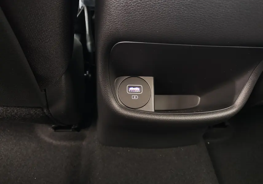 Prise USB de recharge arrière intégrée dans la console centrale noire du Hyundai Kona Electric gris métallisé 2025.