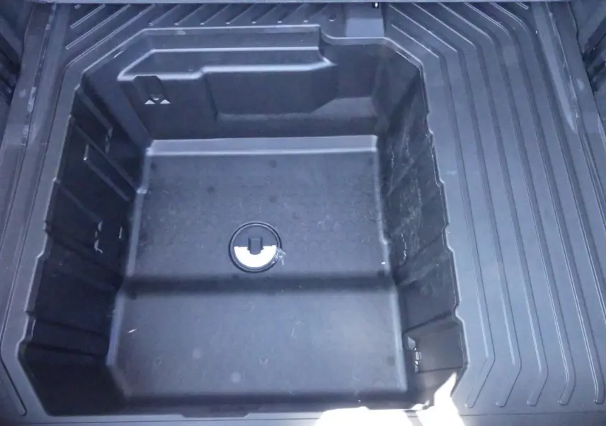 Compartiment de rangement sous plancher de coffre du Ford Puma 2025, vue plongeante sur espace de stockage noir.