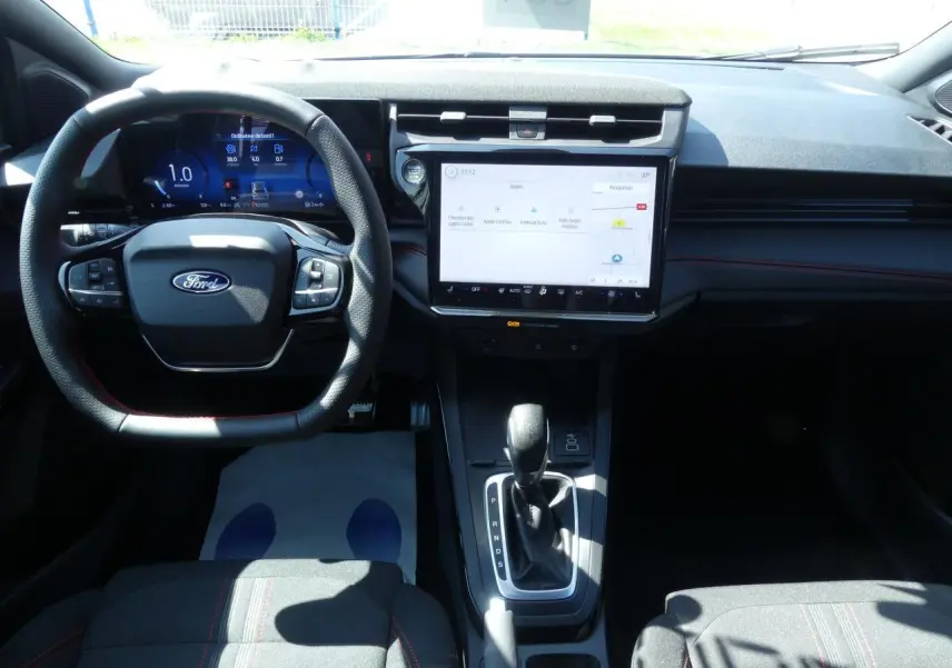 Intérieur du Ford Puma 2025 vu de face, tableau de bord moderne avec écran tactile et volant multifonction noir.
