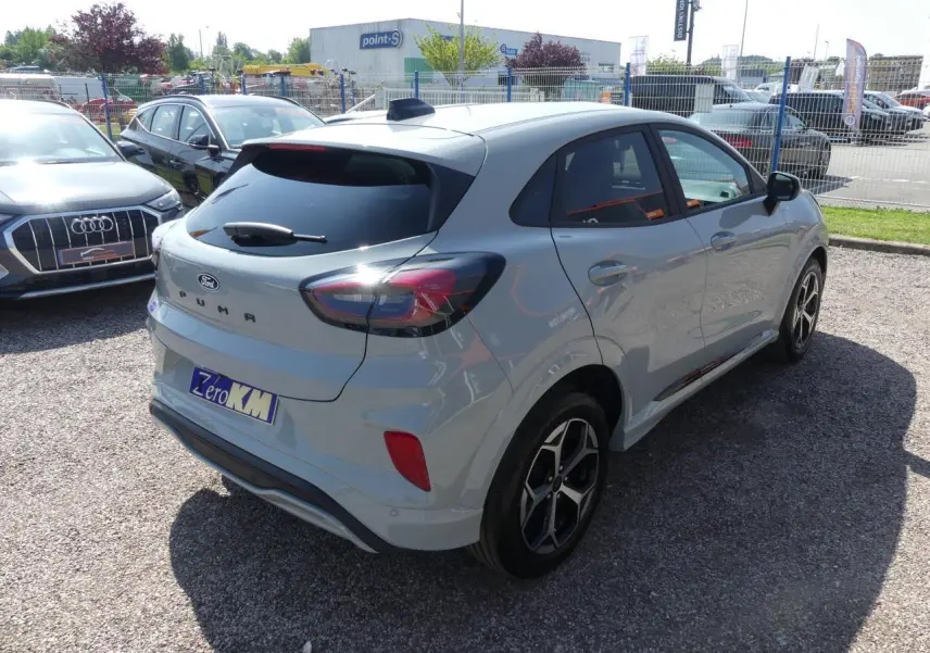 Vue 3/4 arrière droite d'un Ford Puma gris métallisé 2025 avec jantes alliage et vitres arrière surteintées.