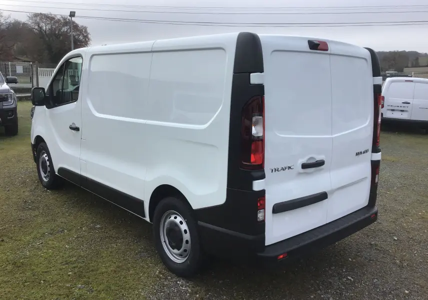 Vue 3/4 arrière droite du Renault Trafic Fourgon blanc, avec feux arrière verticaux et porte arrière double.