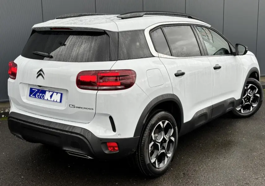 Vue 3/4 arrière droite d'un Citroën C5 Aircross blanc Okénite avec jantes alliage 18'' bi-ton et vitres surteintées.