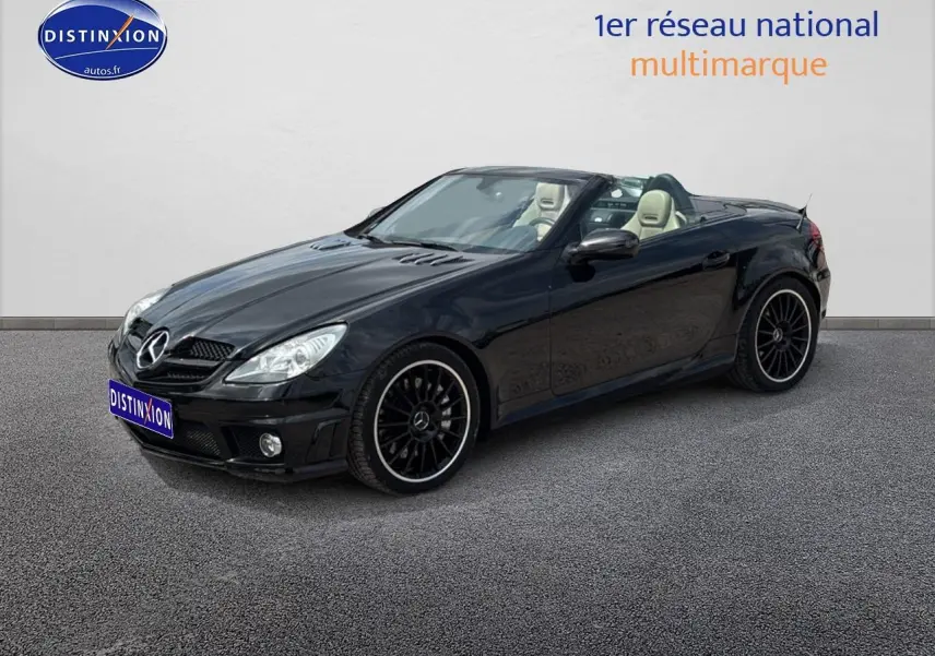 Mercedes SLK 55 AMG noir vue 3/4 avant droit, capote ouverte, jantes alu noires et intérieur cuir clair visible