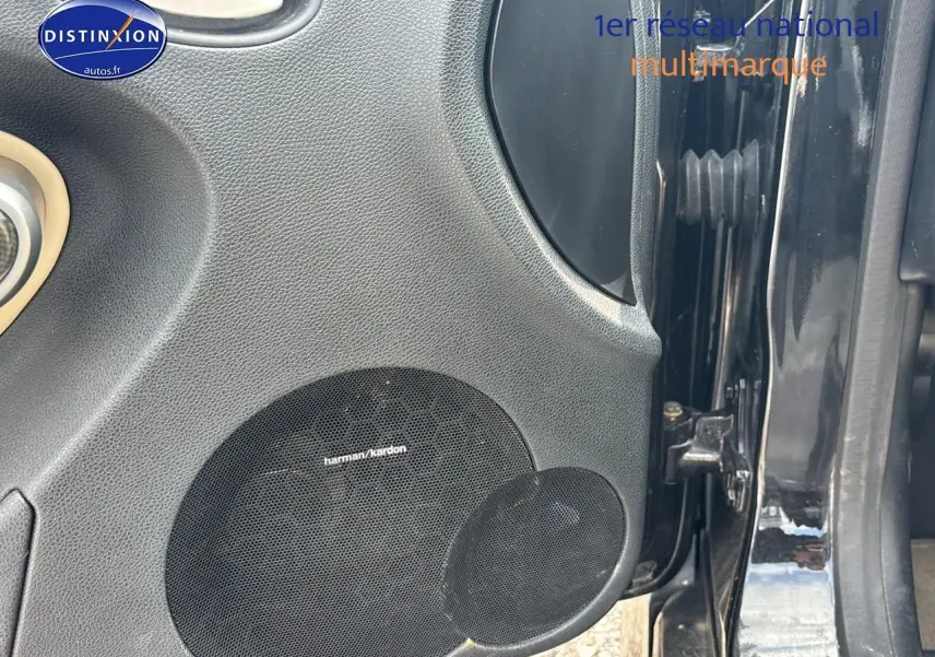 Gros plan sur la porte avant gauche noire d'une Mercedes SLK 55 AMG 7G-Tronic avec haut-parleur Harman Kardon intégré.