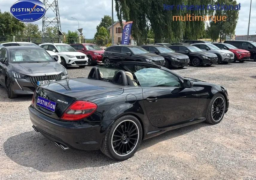 Mercedes SLK 55 AMG noir vue 3/4 arrière droit cabriolet avec jantes alu noires sur parking multimarque