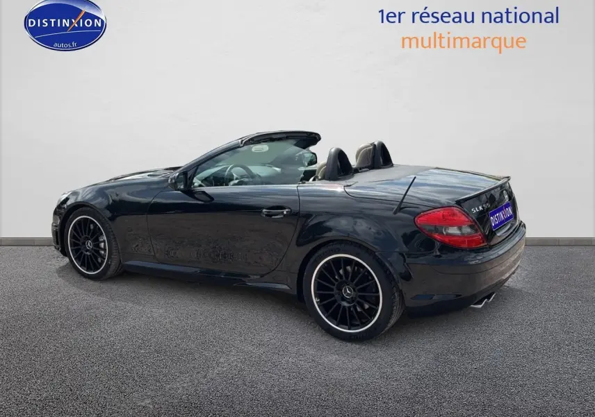 Mercedes SLK 55 AMG noir vue 3/4 arrière côté gauche, cabriolet avec jantes alu noires et intérieur cuir visible.