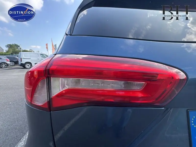 Gros plan sur le feu arrière gauche d'une Ford Focus bleu azur métallisé, soulignant la finition moderne du modèle 2019.