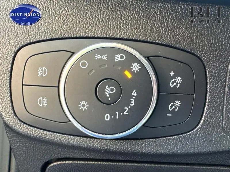 Gros plan sur la molette de réglage des phares avec commandes d'éclairage dans une Ford Focus bleu azur métallisé 2019.