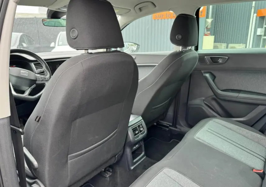 Vue arrière intérieure du SEAT Ateca 2023 avec sièges en textile noir et gris et console centrale avec prises USB-C.