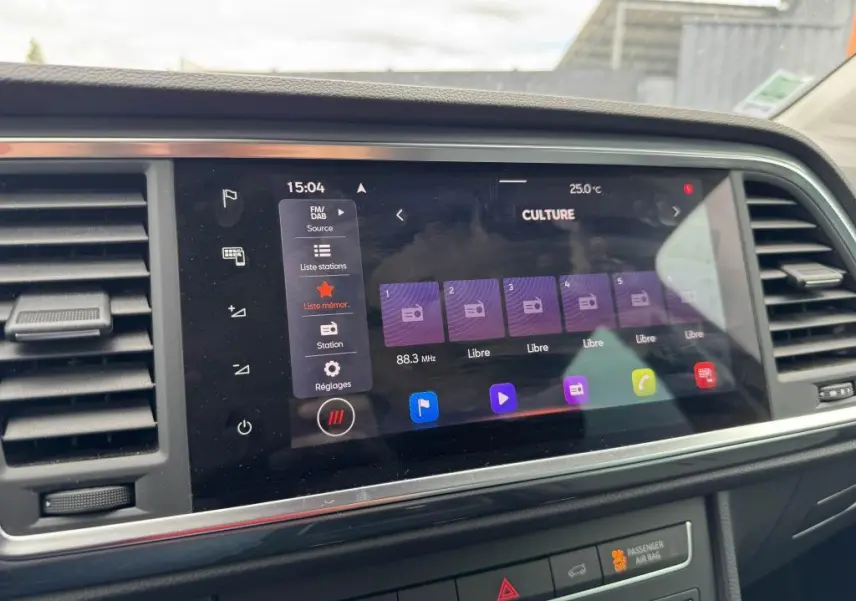Écran tactile central du tableau de bord du SEAT Ateca 2023 noir, affichant la radio FM/DAB et les réglages multimédia.