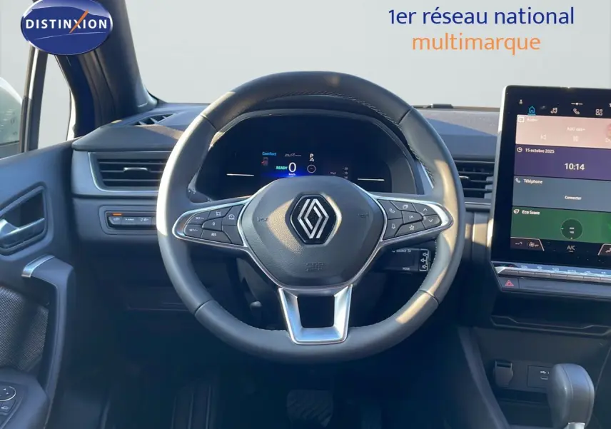 Vue intérieure centrée sur le volant Renault du Captur E-Tech Hybrid 2025 avec tableau de bord numérique et écran tactile.