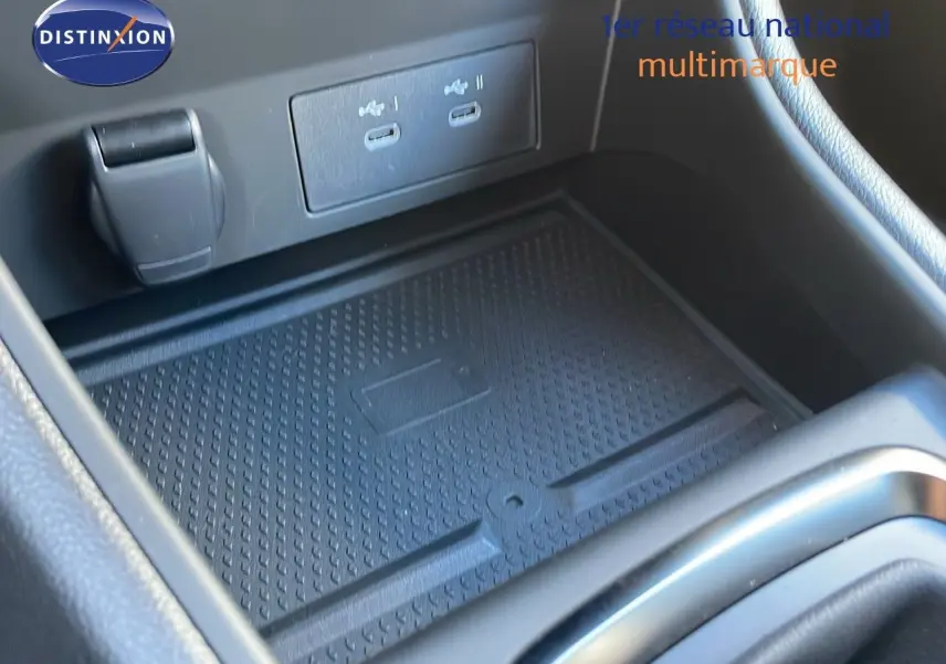 Gros plan sur la console centrale du Renault Captur 2025 avec zone de charge et ports USB visibles.