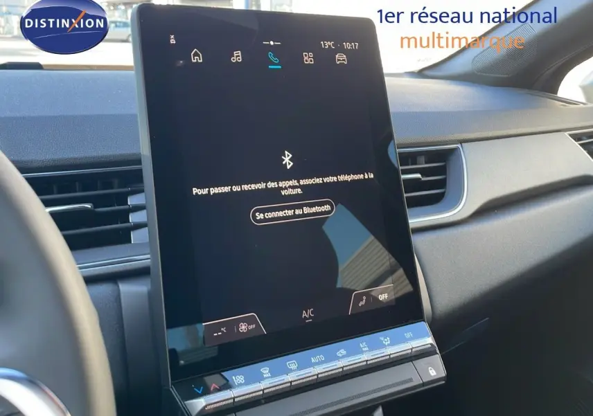 Vue rapprochée de l'écran tactile central du tableau de bord du Renault Captur bleu iron métal avec toit gris.
