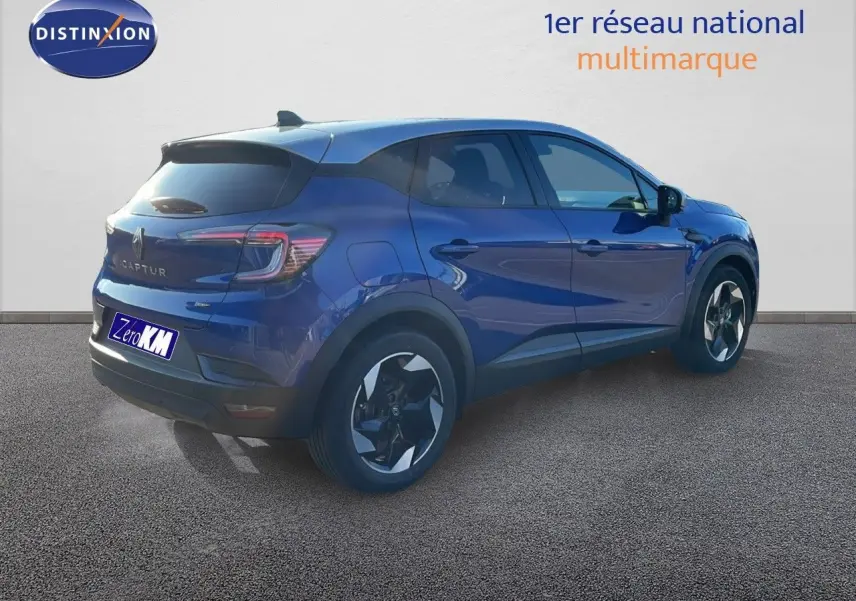 Renault Captur E-Tech hybride bleu Iron Metal avec toit gris, vue 3/4 arrière côté gauche sur sol gris.