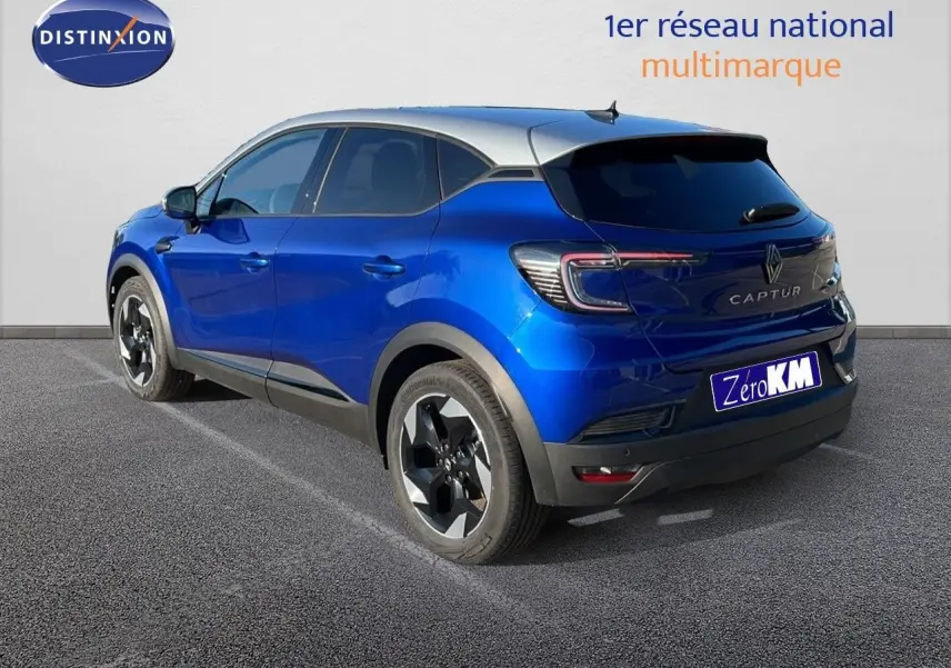 Renault Captur E-Tech hybride bleu Iron métal avec toit gris, vu de trois quarts arrière côté gauche.
