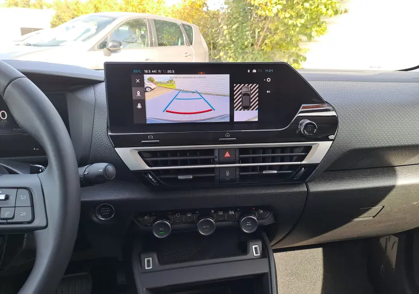 Vue intérieure du tableau de bord du Citroën C4 hybride 2025, avec écran central affichant la caméra de recul.