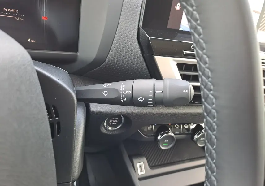 Détail intérieur du commodo d'essuie-glace et bouton start/stop sur Citroën C4 hybride 2025 Manhattan Green.