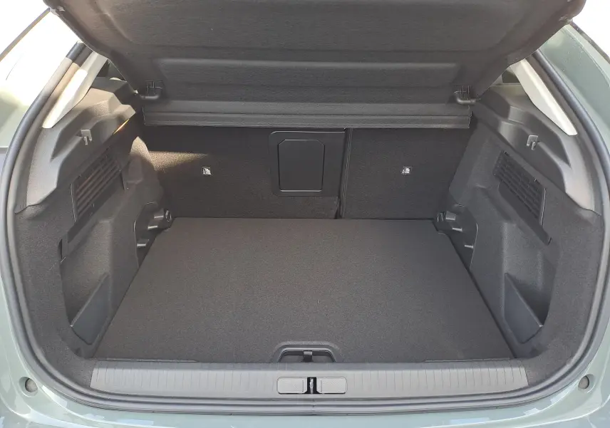 Coffre ouvert vu de l'arrière d'une Citroën C4 hybride 2025 Manhattan Green, montrant un espace de chargement propre et spacieux.