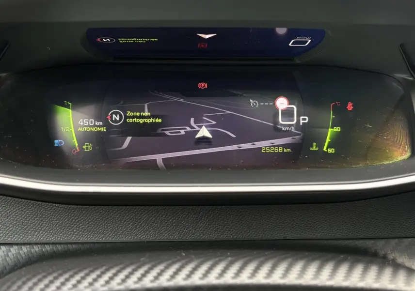 Affichage numérique du tableau de bord Peugeot 208 GT avec navigation 3D et indicateurs de vitesse et autonomie.
