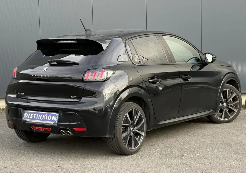 Peugeot 208 GT noire vue en 3/4 arrière droit avec double sortie d’échappement chromée et jantes alliage 17 pouces.
