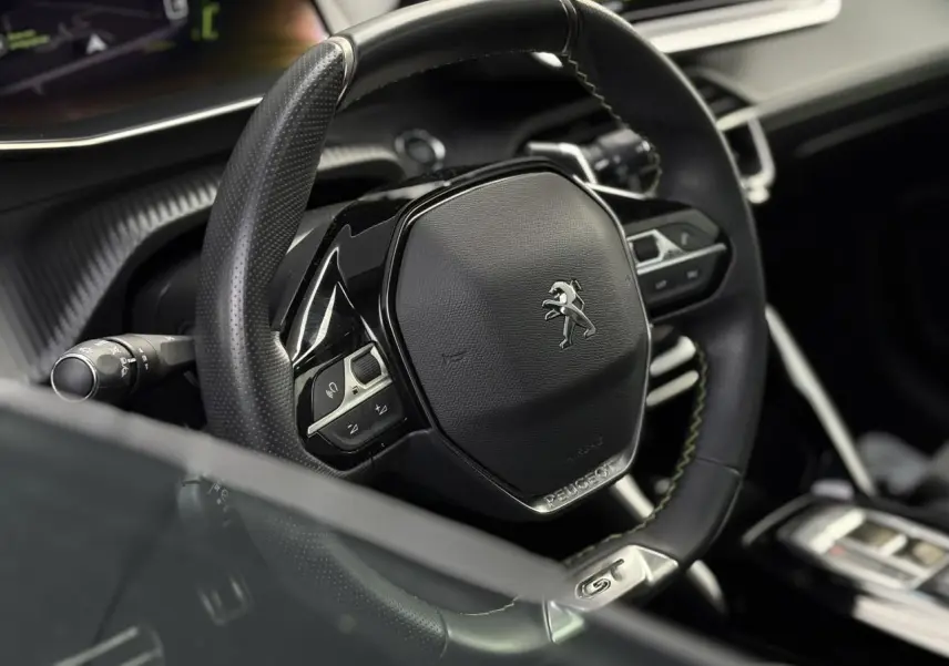 Gros plan sur le volant cuir noir avec badge GT du Peugeot 208 1.2 PureTech 130 EAT8 GT 2023.