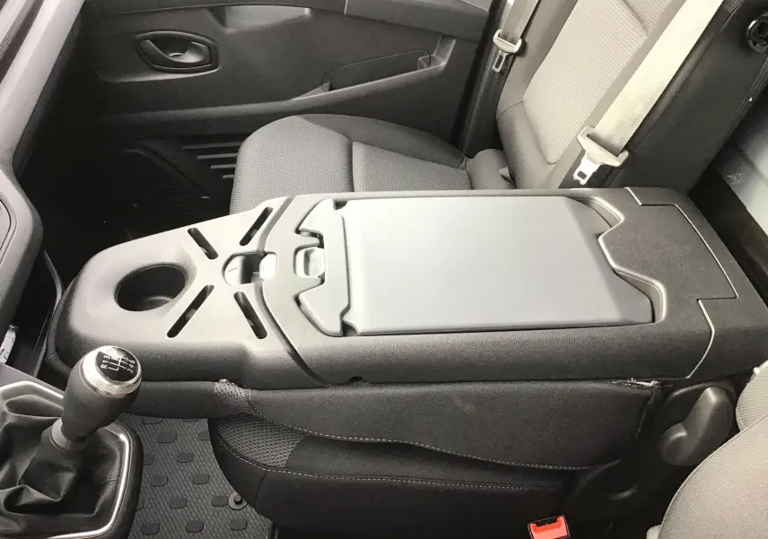 Vue intérieure rapprochée du siège passager et de la console centrale noire du Renault Trafic Fourgon 2025 avec levier de vitesses manuel.