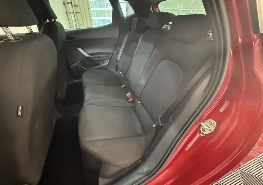 Vue intérieure côté arrière droit sur la banquette noire d'une SEAT IBIZA 1.0 TSI 110 FR rouge 2024.