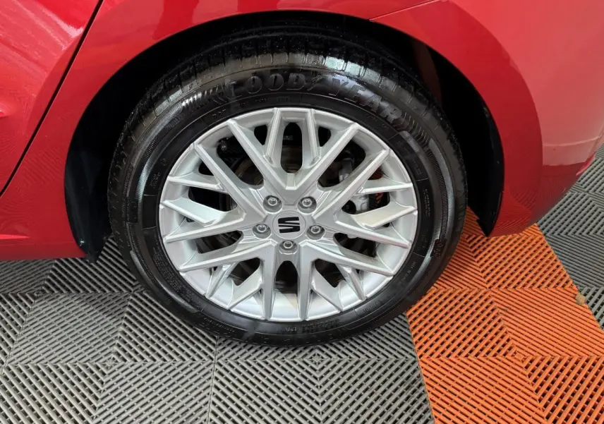 Gros plan sur la roue avant gauche rouge d'une SEAT IBIZA 1.0 TSI 110 FR avec jante alliage argentée détaillée.