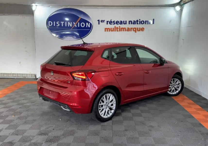 SEAT IBIZA 1.0 TSI 110 FR rouge en 3/4 arrière droit, avec feux LED et jantes alliage visibles dans un showroom.