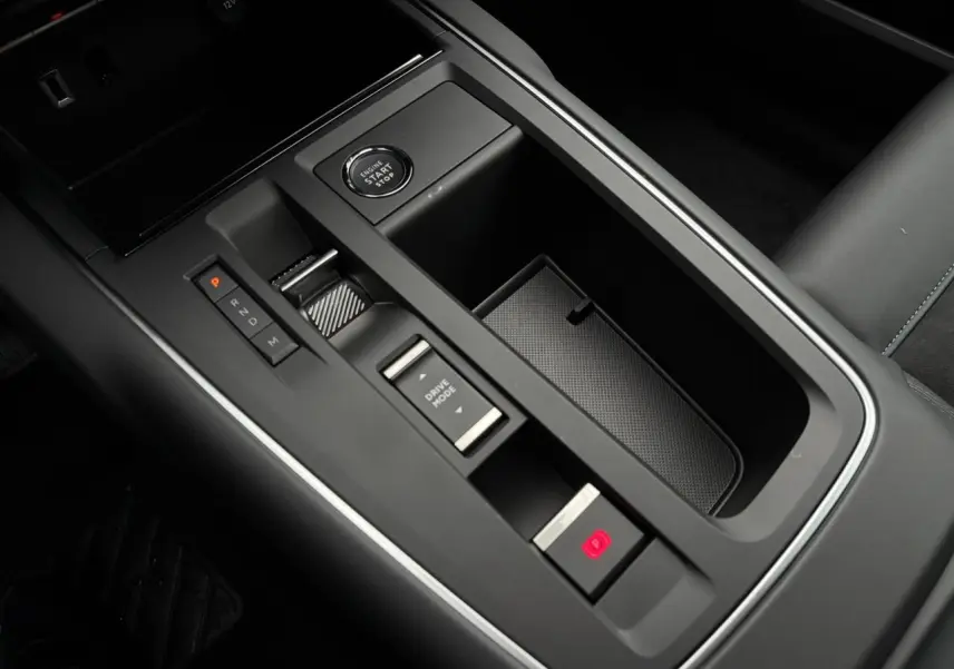 Vue rapprochée de la console centrale noire du Citroën C5 Aircross 2025 avec bouton start/stop et commandes de boîte auto.