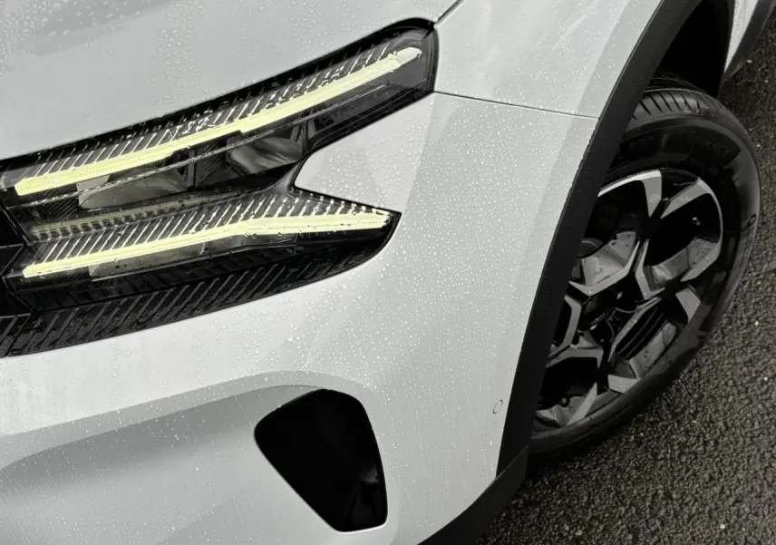 Gros plan sur l'avant droit blanc Okénite du Citroën C5 Aircross 2025 avec feux LED et jante alliage bi-ton.