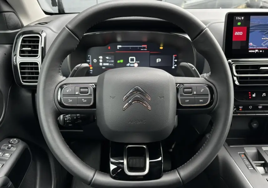 Vue frontale du volant noir de la Citroën C5 Aircross 2025 avec tableau de bord numérique et écran tactile.