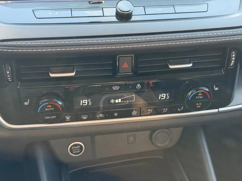 Vue rapprochée de la console centrale du Nissan Qashqai 2025 noir, montrant les commandes de climatisation digitale et le bouton start/stop.