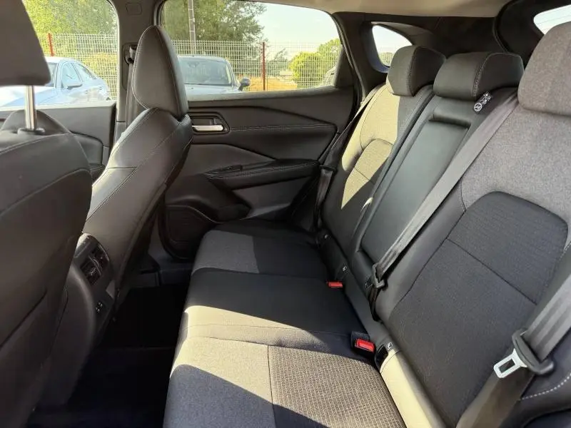 Vue intérieure du côté droit de la banquette arrière noire du Nissan Qashqai 2025 avec ceintures et appuie-têtes visibles.