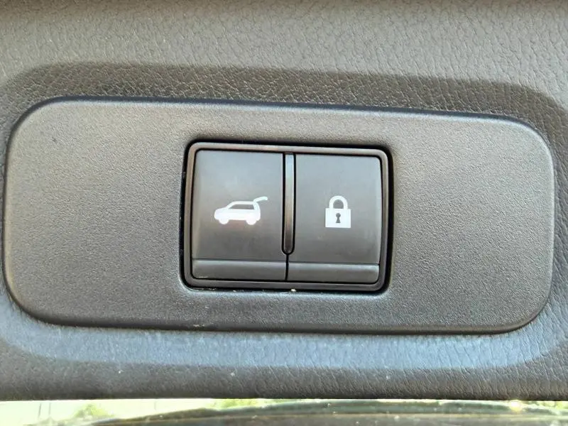 Gros plan sur les boutons noirs d'ouverture du coffre et de verrouillage central du Nissan Qashqai 2025.