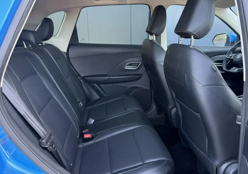 Vue intérieure côté gauche montrant la banquette arrière en tissu et similicuir noir du MG ZS bleu Como 2025.