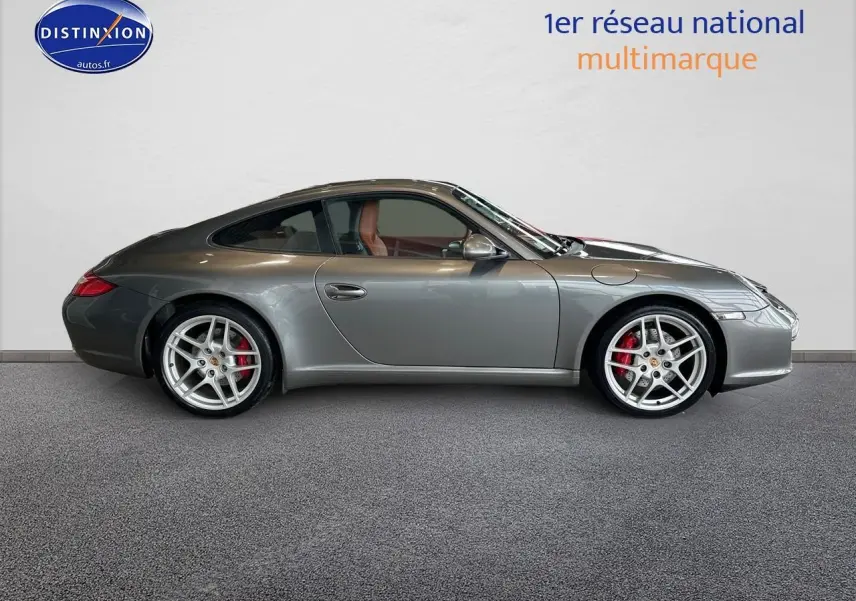Profil latéral droit d'une Porsche 911 (997) Carrera PDK gris métallisé avec jantes alu et intérieur cuir marron.