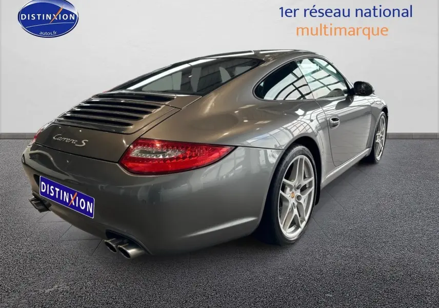 Vue 3/4 arrière droite d'une Porsche 911 Carrera S grise de 2009 avec jantes alu et feux arrière LED.