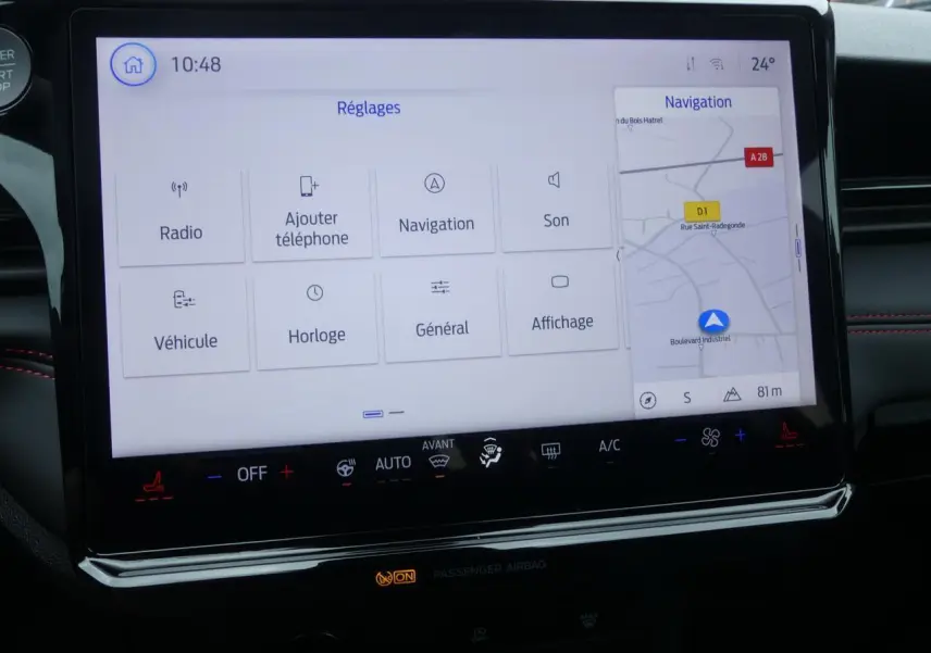 Écran tactile central du Ford Puma 2025 affichant le menu Réglages et la navigation, avec surpiqûres rouges visibles.